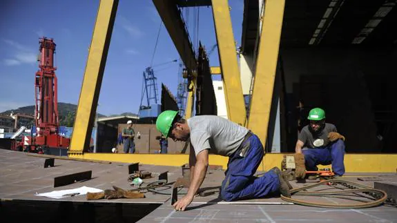 Dos empleados trabajando en un astillero. 