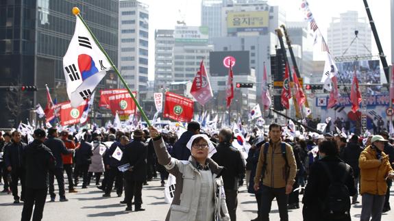 Manifestantes en contra y a favor del cese de la presidenta surcoreana.