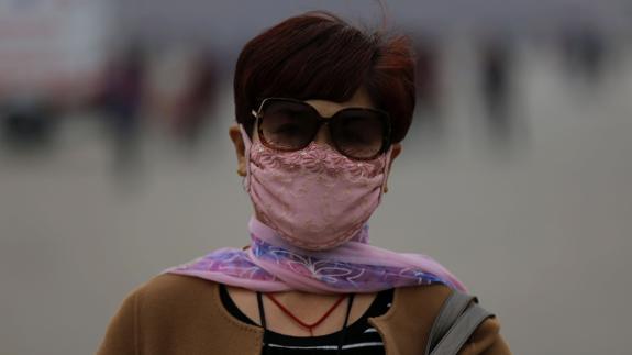 Una mujer, con mascarilla.