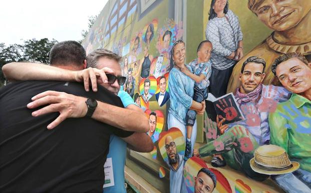 Un familiar de una víctima se abraza con uno de los artistas participantes en el homenaje. 