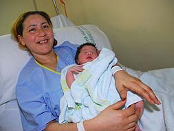 Aisha sostiene feliz a su nueva hija, Nisrin. / EVA GUZMÁN