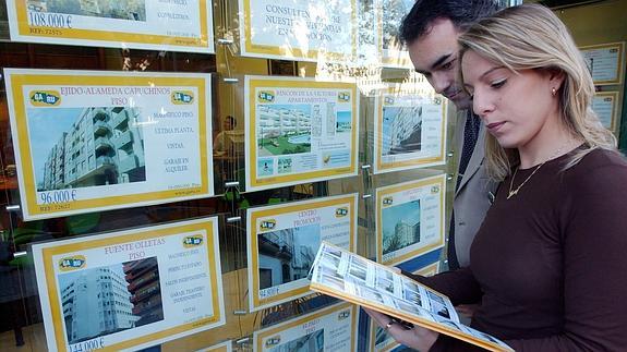 Una pareja analiza promociones de una inmobiliaria 