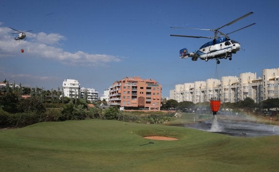 Helicópteros recargan agua en un campo de golf junto a una urbanización de Torremolinos. :: salvador salas
