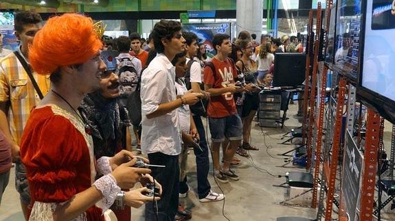 Un grupo de jóvenes, algunos ataviados como sus personajes favoritos, juegan en uno de los expositores. 