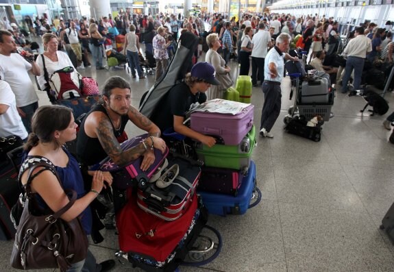 Viajeros hacen cola ante los mostradores para facturar sus equipajes. :: carlos moret