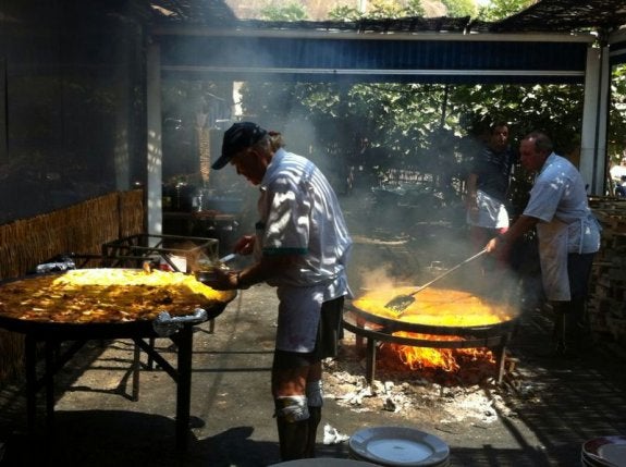Ayo sigue haciendo las paellas con fuego de leña, a la vista de todos.