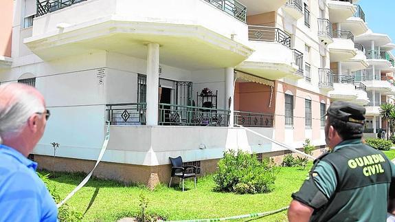 Un agente, frente a la vivienda donde se produjo el crimen, en una urbanización de Torrox. 