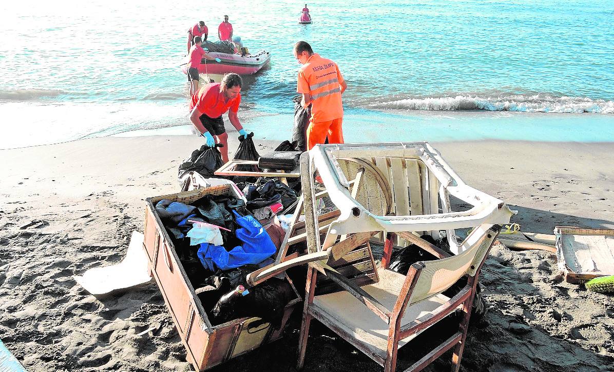 Operarios del servicio municipal de limpieza y socorristas, ayer, retiran los enseres de la playa. 