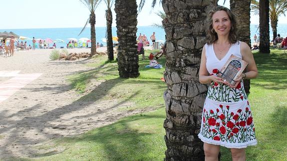 María Luisa Martín posa con su novela en la playa de La Carihuela