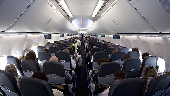 Vista interior de la clase turista de un avión de pasajeros. 