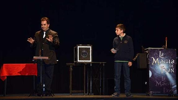 Uno de los ilusionistas realiza un truco de magia con un niño como ayudantes. 
