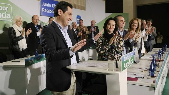 Juanma Moreno recibe los aplausos de sus compañeros de partido durante la reunión de la junta directiva regional del PP andaluz ayer en Sevilla. 