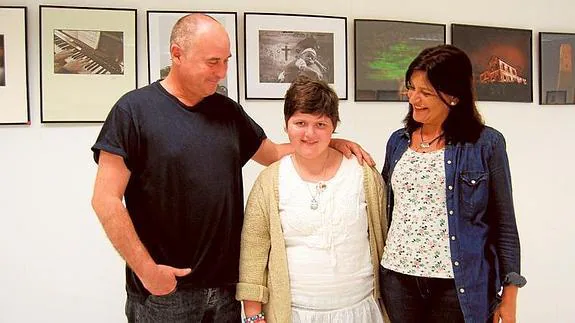 Patricia posa con sus padres junto a su fotografía favorita en la exposición en Los Boliches.