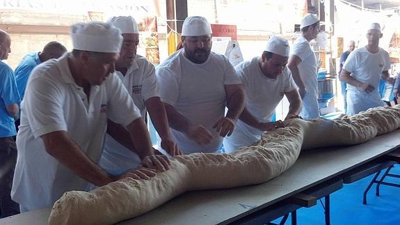 Las dimensiones del pan ha obligado a varias personas a amasarlo y darle forma. 