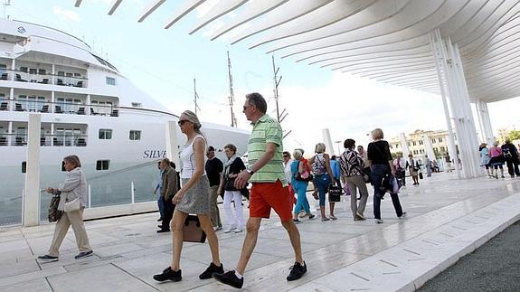 Turistas contemplan los cruceros atracados en el puerto de Málaga.