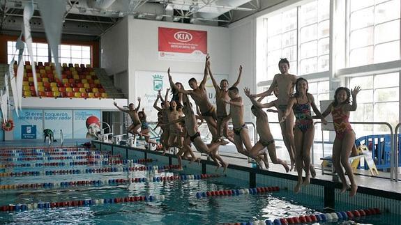 Los integrantes de los equipos alevín e infantil del Inacua saltan a la piscina del club malagueño.