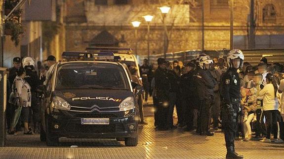 Agentes de la Policía Nacional de Málaga, frente al edificio situado en la plaza de la Biznaga, en la barriada de García Grana, donde un vecino apuñaló a otro causándole la muerte en 2012.