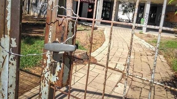 La puerta de entrada al recinto del colegio mayor, solo cerrada por un alambre