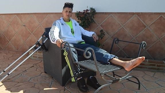Sofía con el pie en alto en la casa de Alhaurín el Grande, donde vive de alquiler desde hace un año. A la izquierda, bengalas en el Camp Nou. 