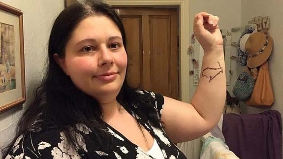Sara Coleman, de 33 años, muestra el tatuaje de la cabra montés. 