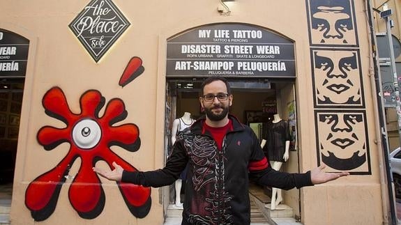 Manuel Criado muestra los grafitis pintados por Obey y por Suso33 en la puerta de su negocio. 