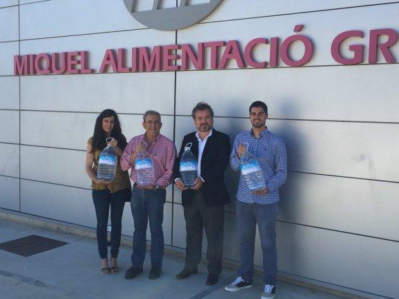 Responsables del Ayuntamiento y de la empresa muestran agua de la donación.