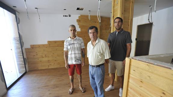 El Bere, en el centro, junto a sus hijos en el local que están remodelando para abrir el negocio 