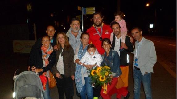 Vivas posa con toda su familia (padres, hermanos, sobrinos y su pareja), de noche en las calles de Suiza tras su plata europea en peso.