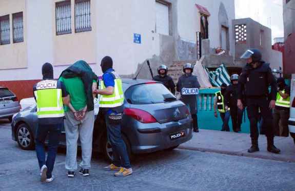 La policía custodia al detenido ayer en Melilla en la operación antiyihadista. :: Ángela Ríos / afp
