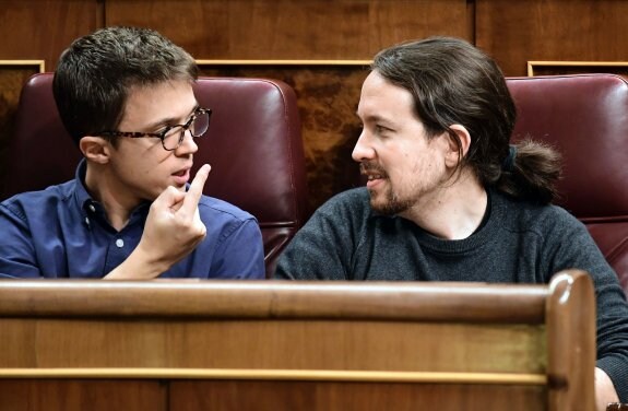 Íñigo Errejón y Pablo Iglesias conversan en sus escaños en el Congreso. :: javier soriano / afp