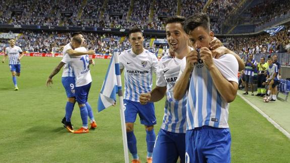 Juanpi besa el escudo del Málaga tras su gol a Osasuna.