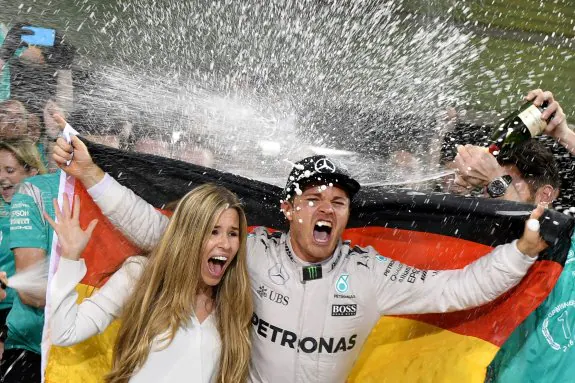 Nico Rosberg, eufórico, rociado de champán, junto a su
esposa, Vivian Sibold, tras conquistar el título. :: afp