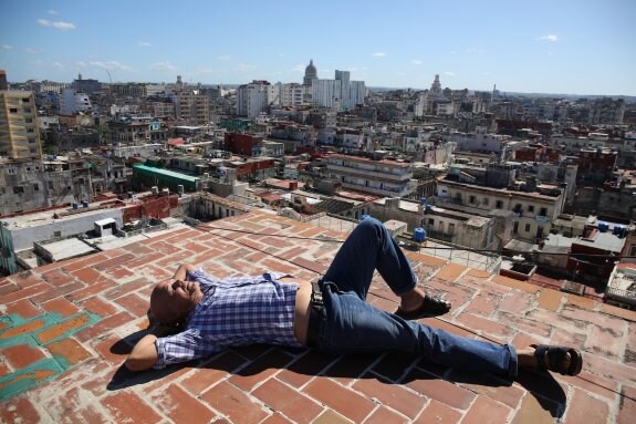 Pedro Juan Gutiérrez, cronista literario de La Habana, descansa en la terraza de su casa desde donde se contempla la ciudad. :: Luis Ángel Gómez