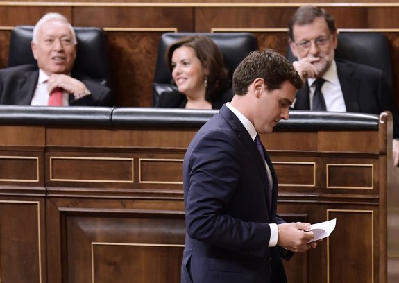 Rivera pasa por delante del escaño de Rajoy durante el debate de investidura en el Congreso. :: javier soriano / AFP
