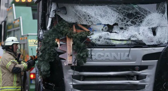 Un bombero asegura los daños sufridos por la cabina del camión empleado en el atentado. :: Hannibal Hanschke / reuters
