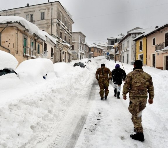 Soldados caminan por Campotosto (Abruzzo) donde la nieve cubre los coches. :: Claudio Lattanzio / efe