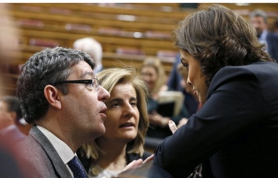 Los ministros Álvaro Nadal y Fátima Báñez conversan con la vicepresidenta Sáenz de Santamaría. :: efe