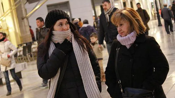 Dos mujeres pasean abrigas por el centro de Málaga.