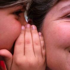 Una niña cuenta un secreto a su madre.
