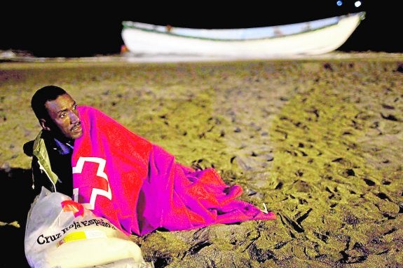 Un inmigrante subsahariano recibe ayuda de Cruz Roja tras llegar a una playa andaluza. :: sur