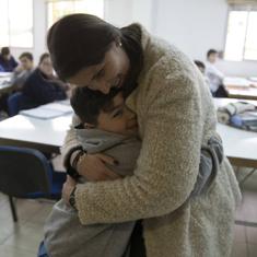 Nena y Brian se abrazan en el interior de un aula en la que estudian decenas de alumnos .