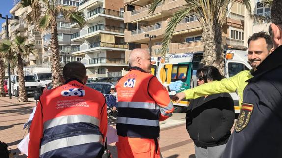 Miembros del 061 y el policía que hizo las primeras maniobras de reanimación se saludan tras conseguir que el hombre saliera con vida del paseo marítimo.