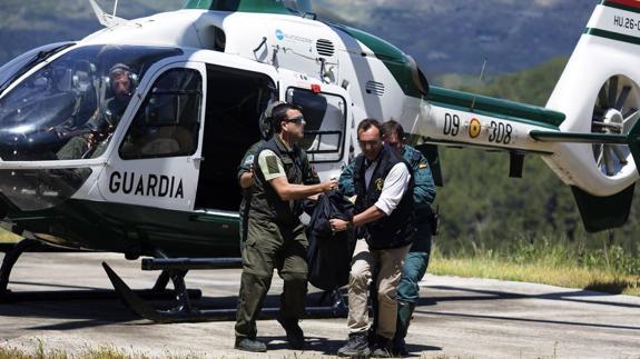 Un equipo de la Guardia Civil traslada uno de los cadáveres, después de ser rescatado. 