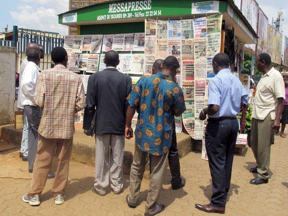 Ciudadanos observan ejemplares de periódicos en un quiosco de Yaundé, en Camerún. :: AFP