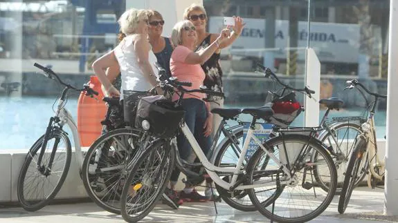 Turistas inmortalizan su recorrido en bicicleta por la ciudad de Málaga. 