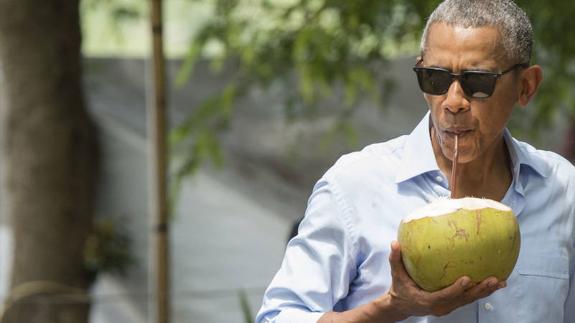 El expresidente de EEUU combate el calor refrescándose con el contenido de un coco en mangas de camisa.