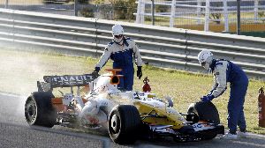 FUEGO. Los bomberos tuvieron que intervenir en el Renault de Fernando Alonso. / REUTERS