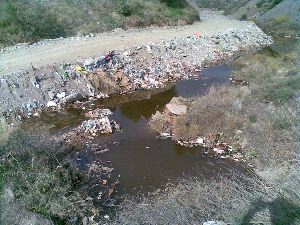 Denuncian a una empresa por verter escombros y plásticos en un arroyo