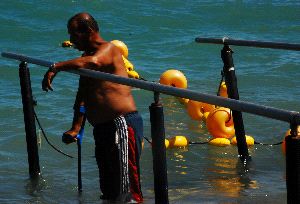 PLAYA PARA TODOS. Un bañista utiliza una de las muletas especiales para el mar. / SKN