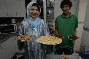 Fátima y su hijo mayor, Osam, muestran los platos que suelen comer cuando se pone el sol./ ANTONIO SALAS